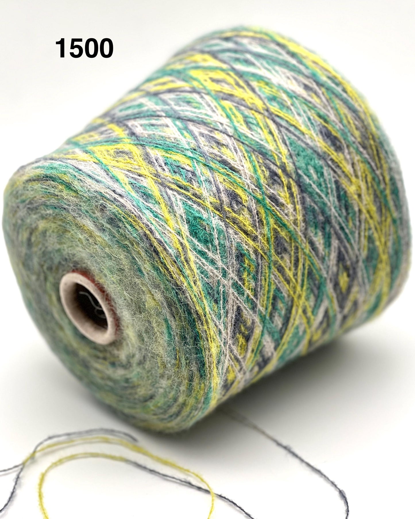 Spool of multicolored yarn with a needle on a white background