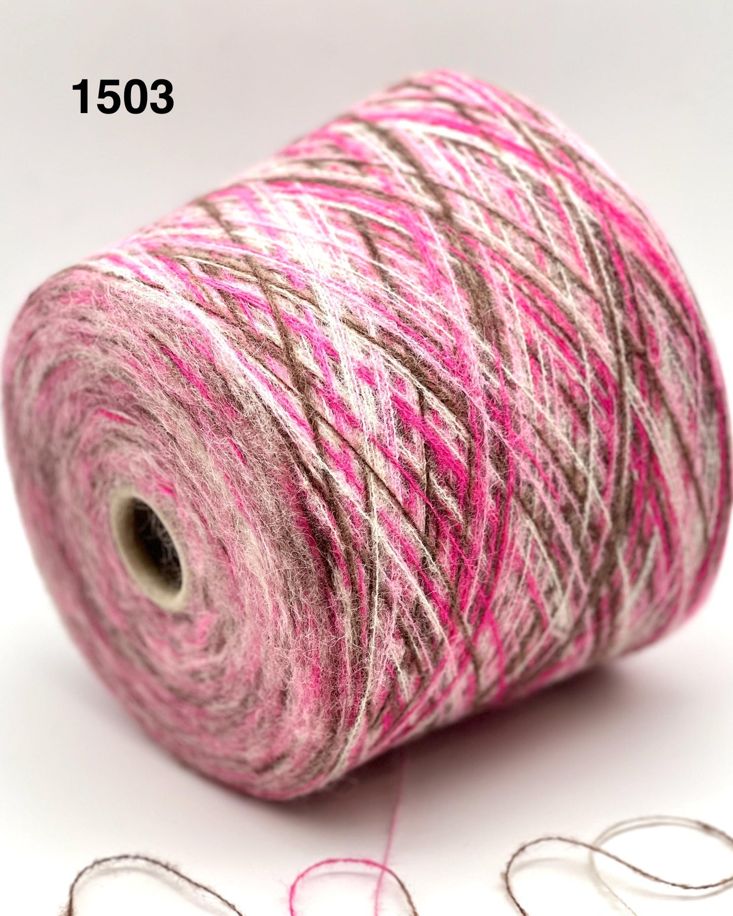 Spool of pink and gray yarn on a white background