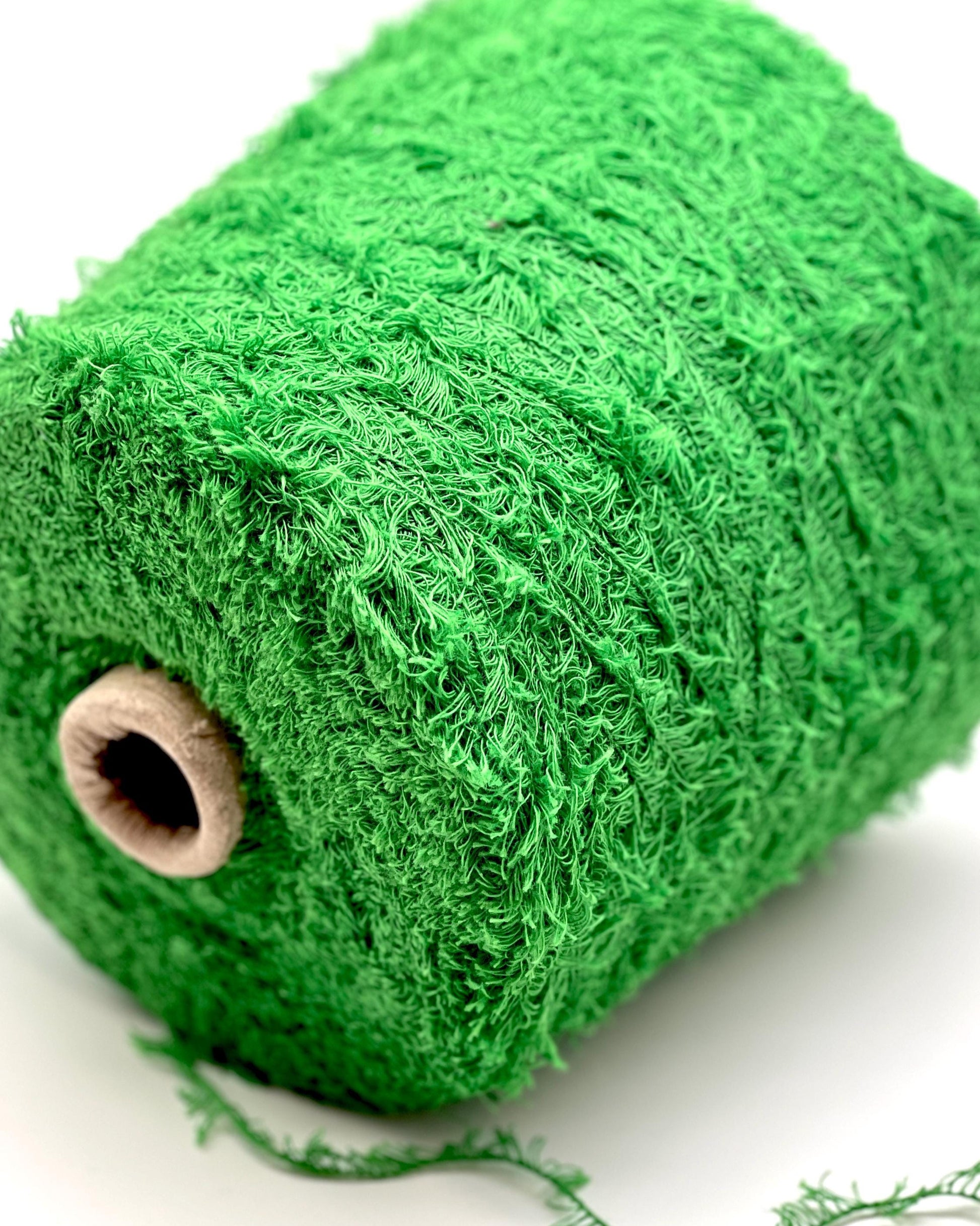 Green yarn roll on a white background