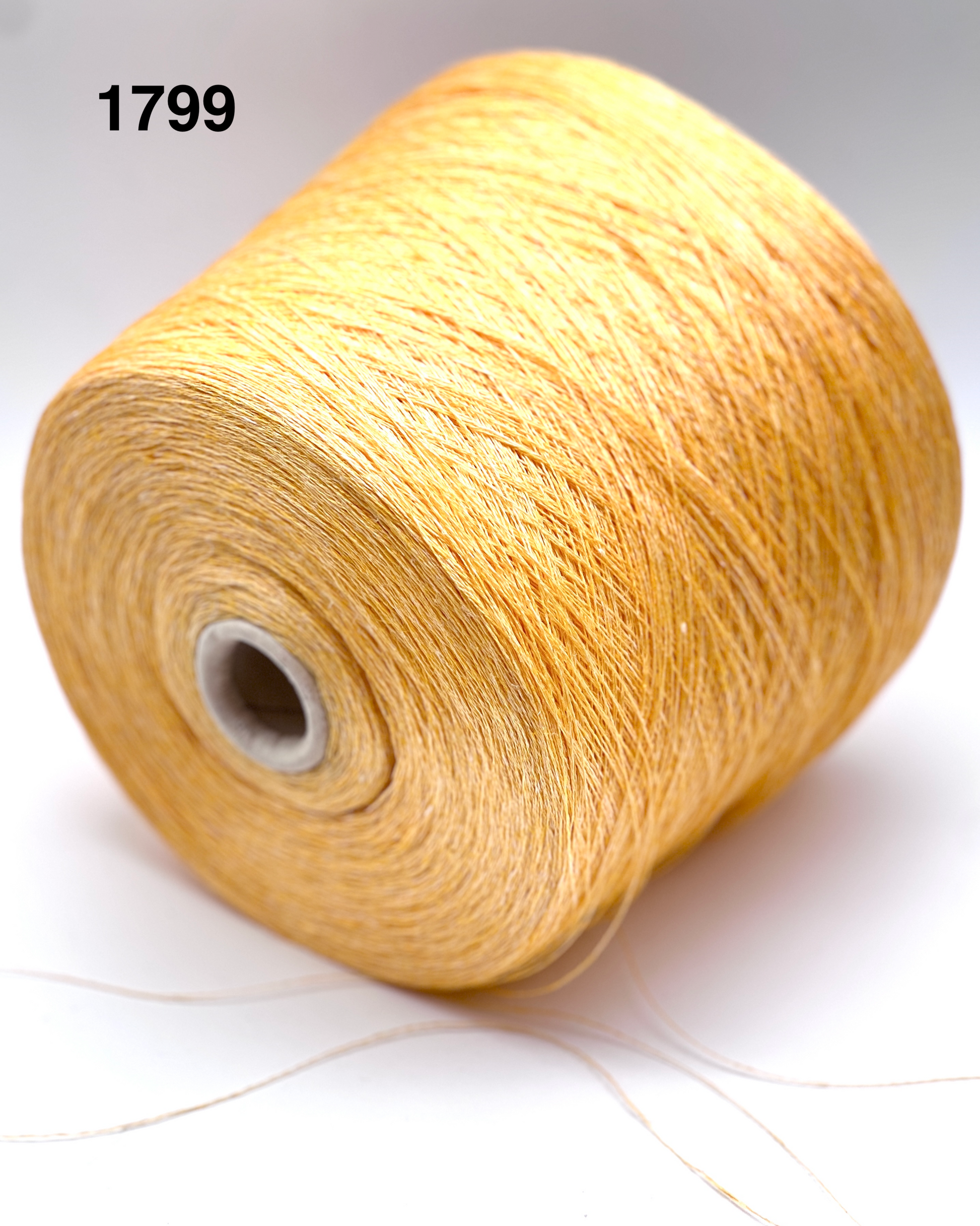 Spool of beige yarn on a white background