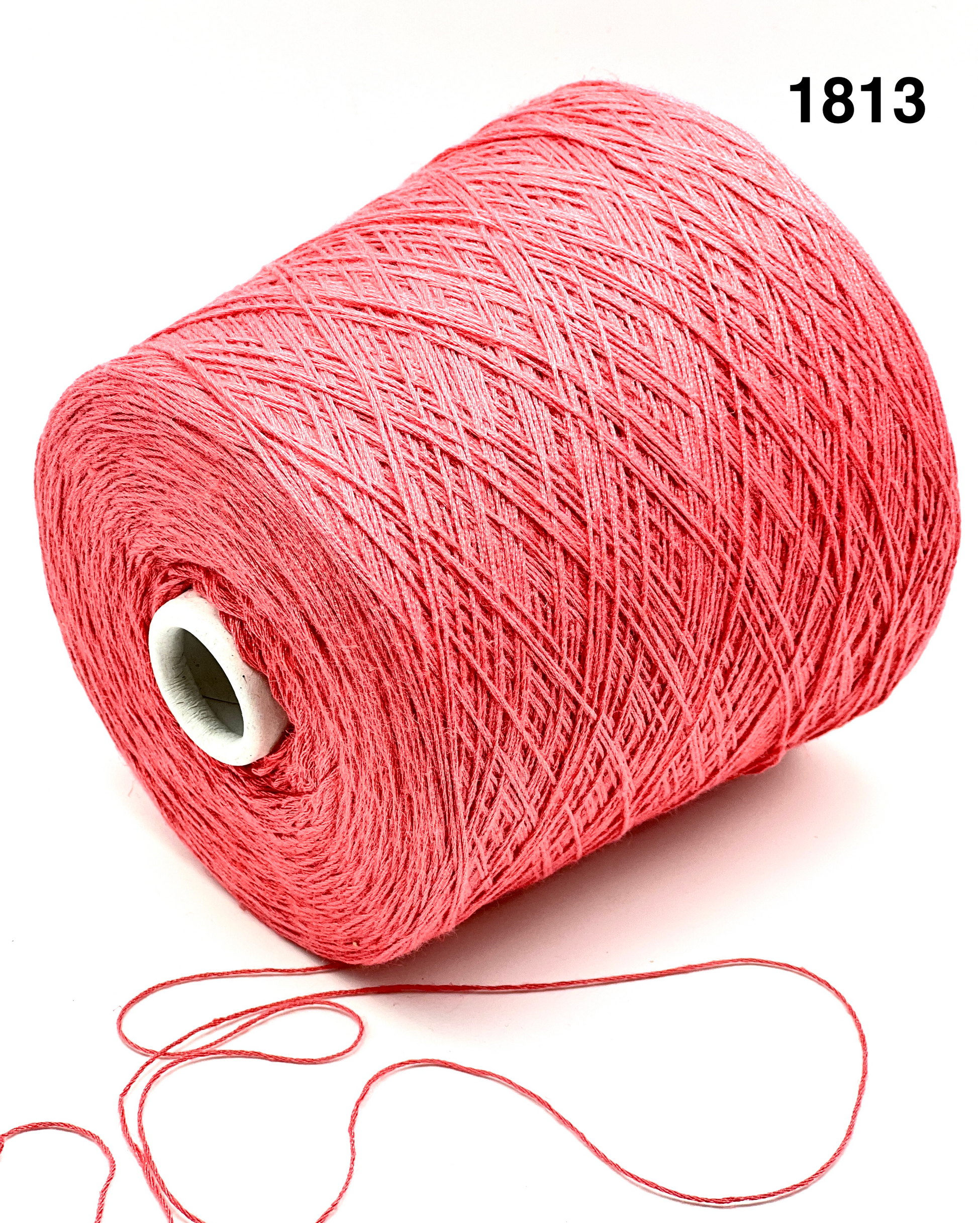 Spool of pink yarn with a small ball of yarn on a white background