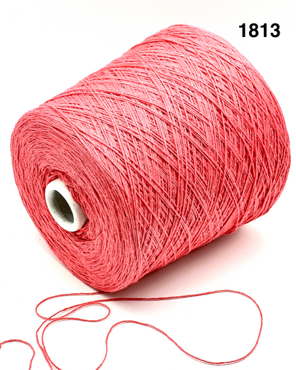 Spool of pink yarn with a small ball of yarn on a white background