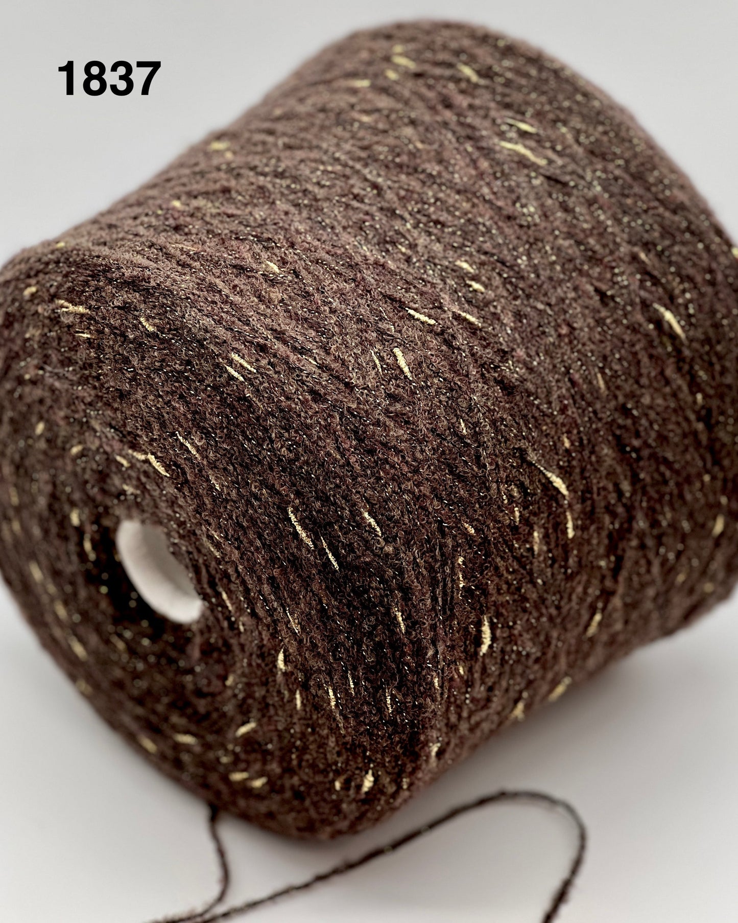 Close-up of a brown spool of thread with visible label '1837'.