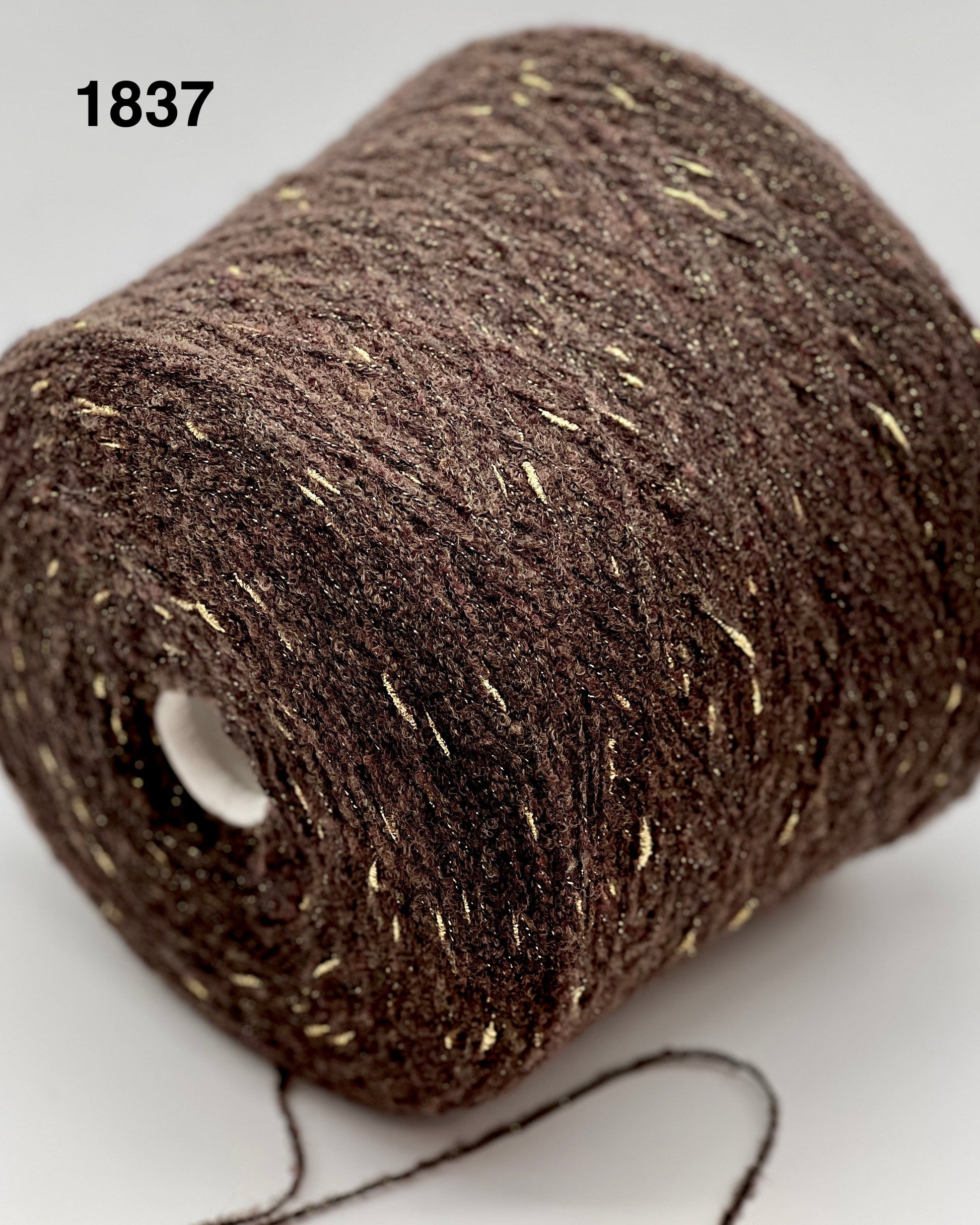 Close-up of a brown spool of thread with visible label '1837'.