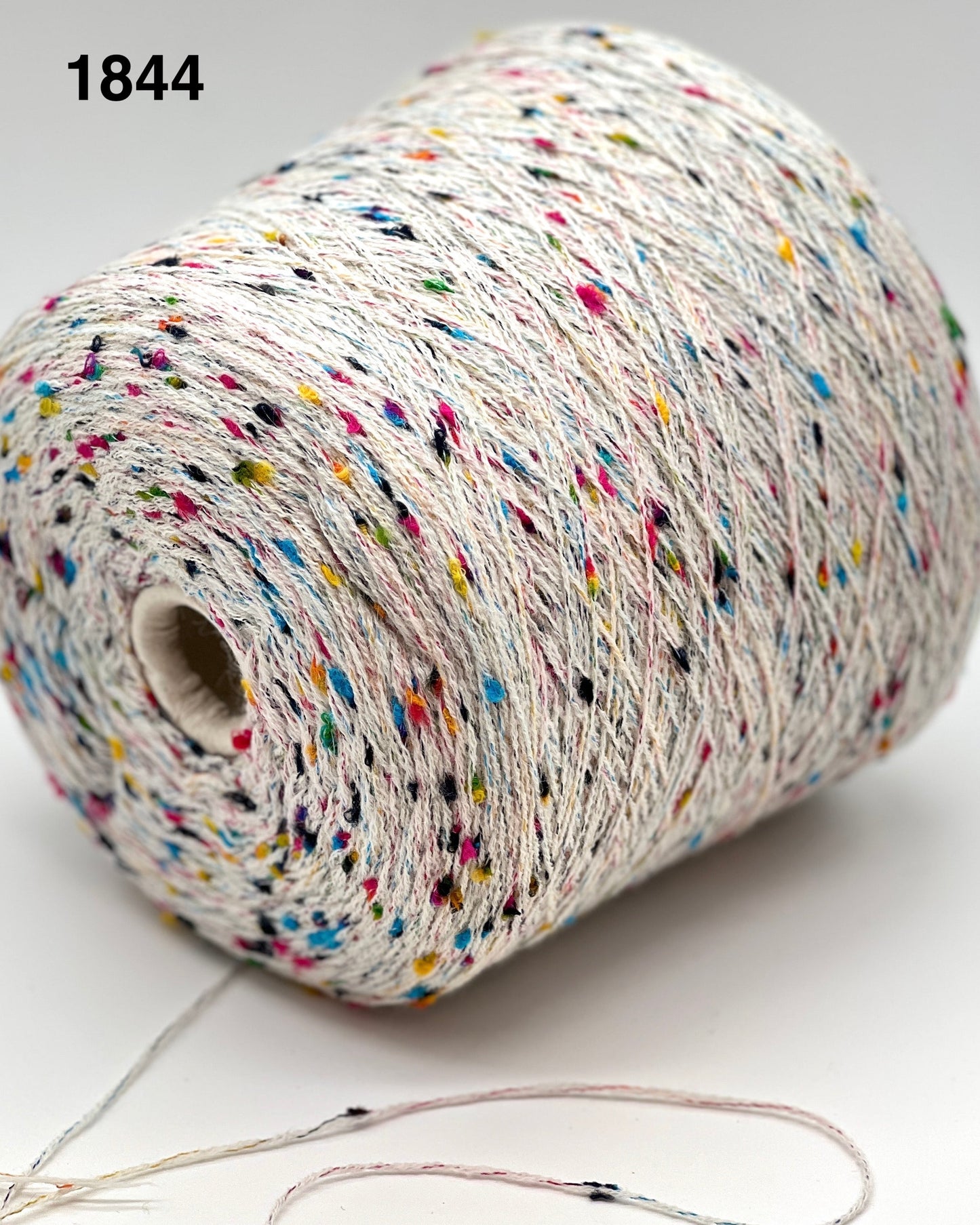 Spool of multicolored yarn on a white background