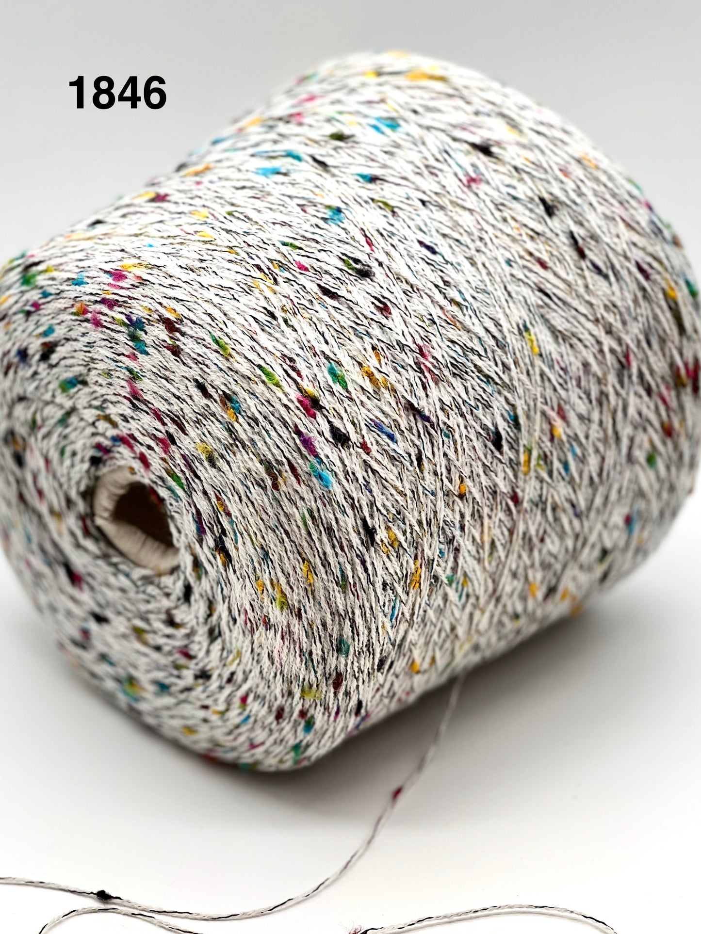 Spool of multicolored yarn on a white background