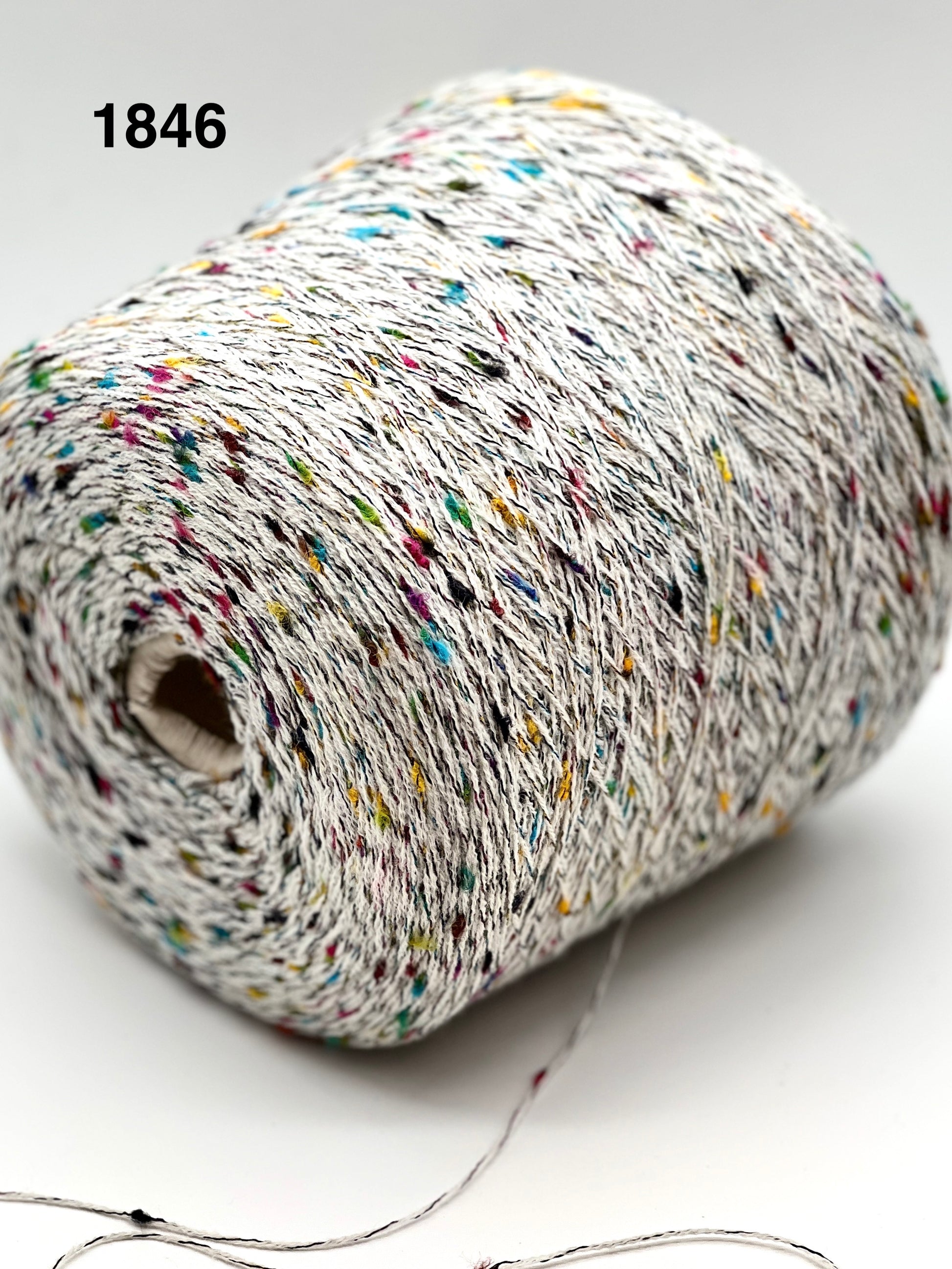 Spool of multicolored yarn on a white background