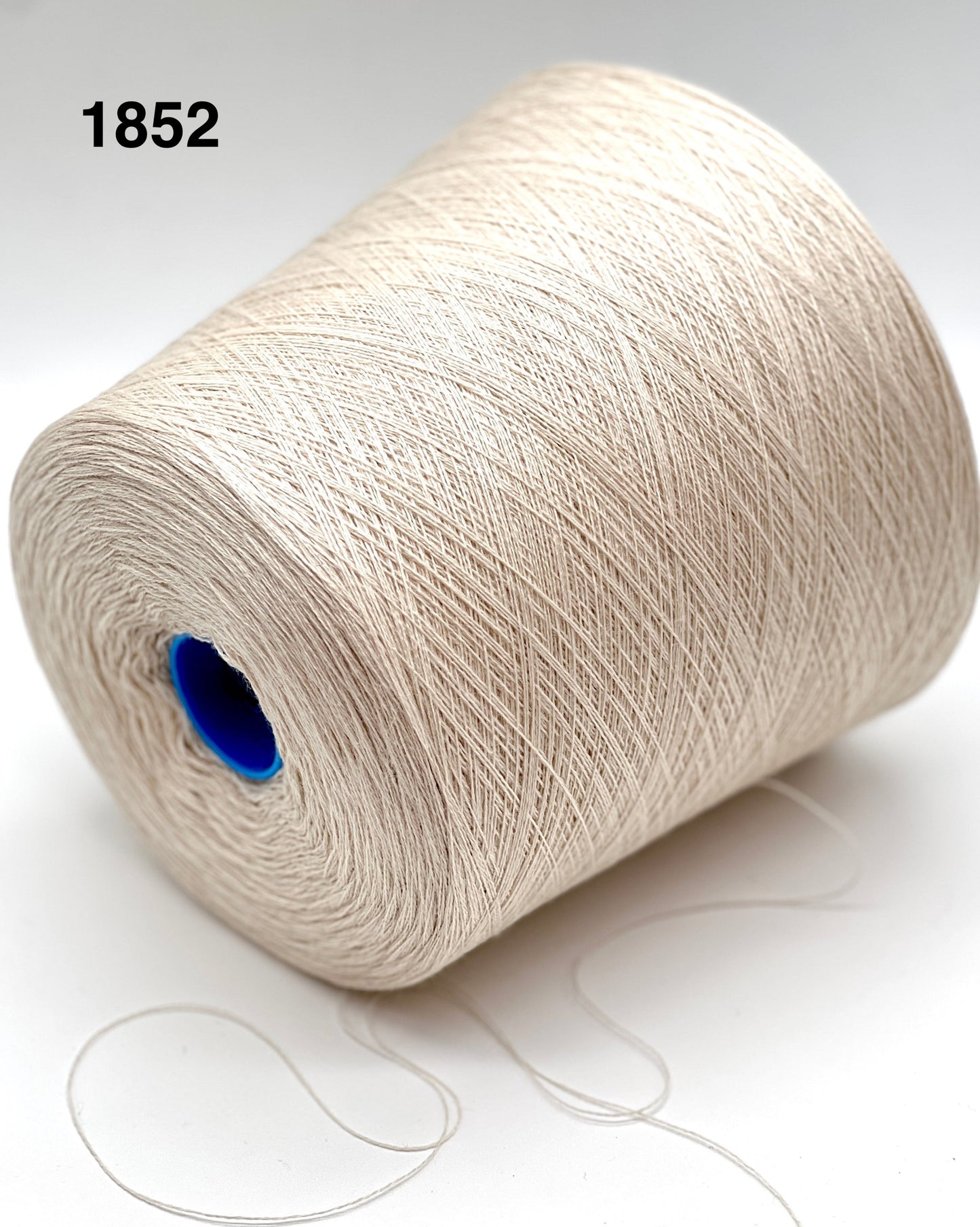 Spool of white yarn with a blue core on a light background
