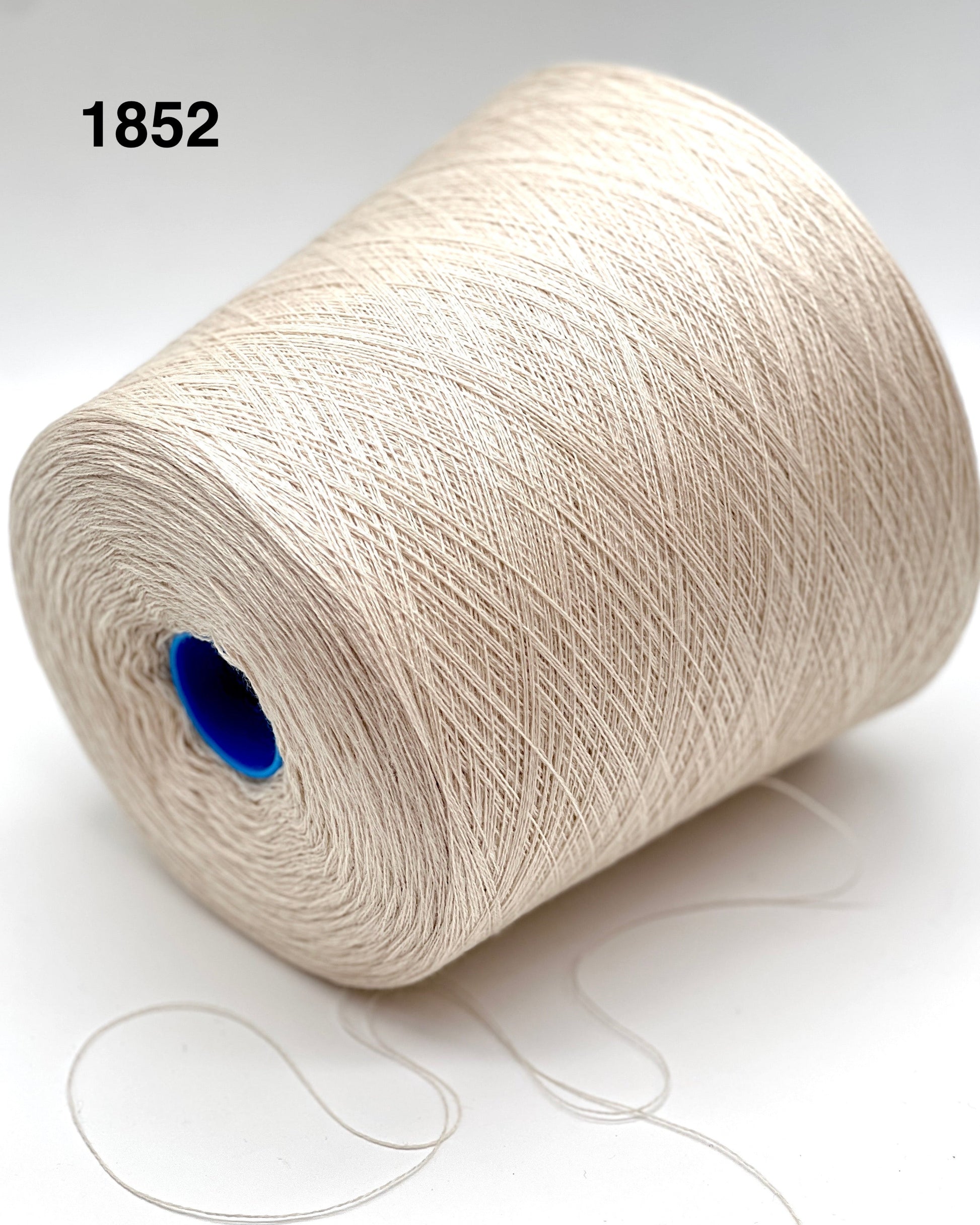 Spool of white yarn with a blue core on a light background