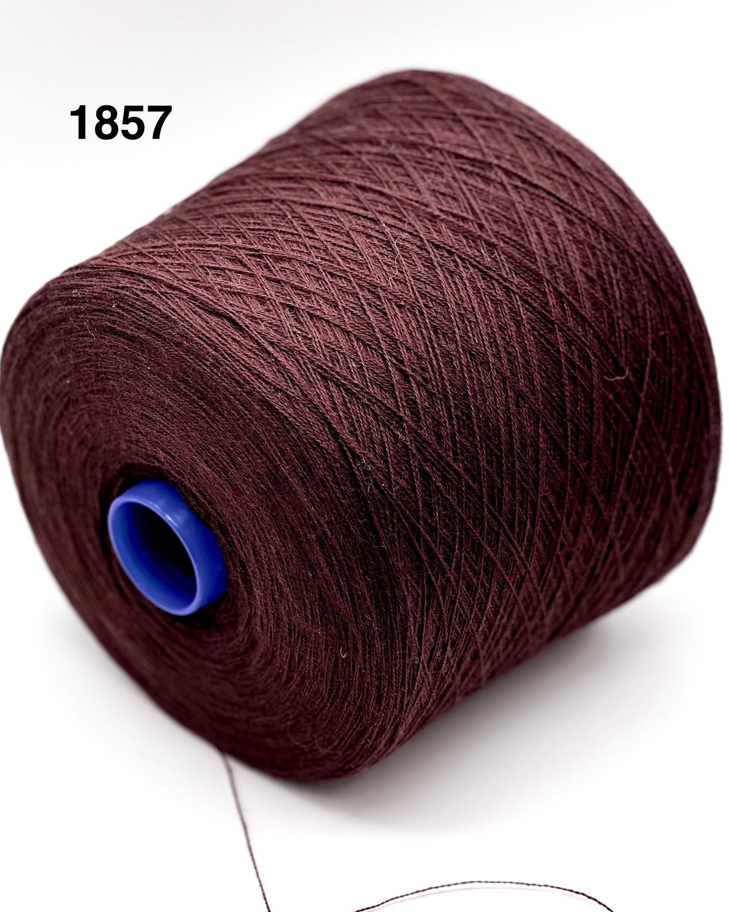 Brown spool of yarn with a blue core on a white background