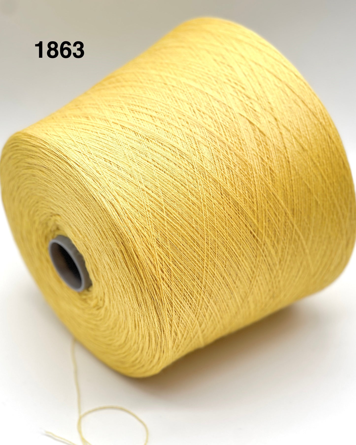 Spool of yellow thread on a white background with number 1863.