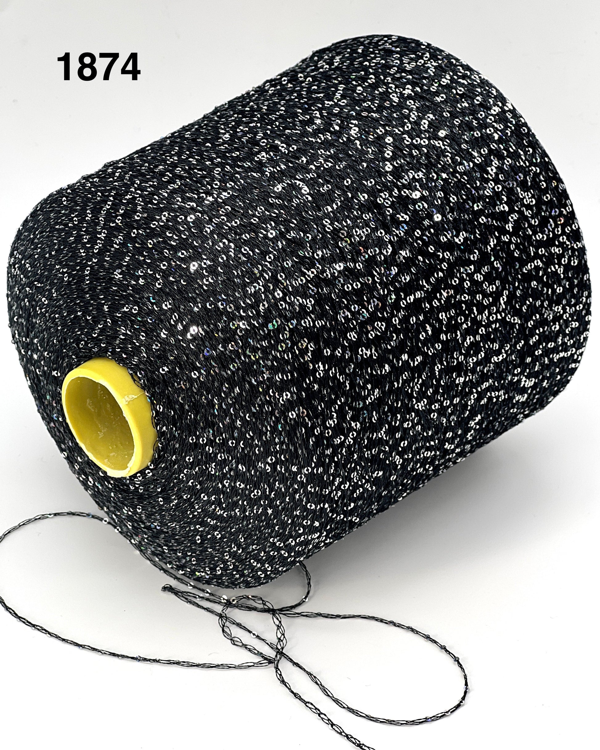Spool of black thread with a yellow core on a white background