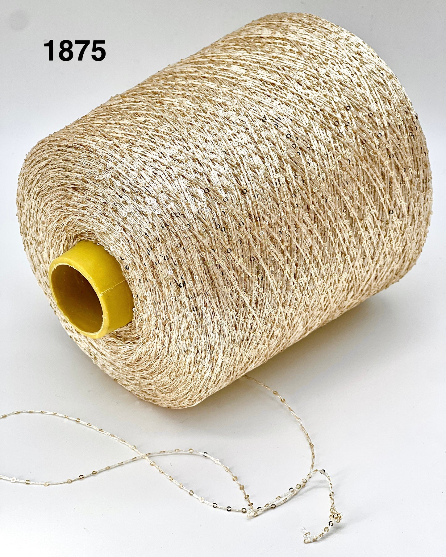 Spool of beige thread with a yellow core on a white background
