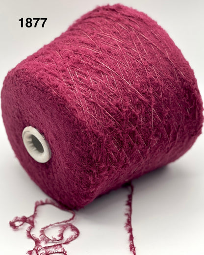 Maroon yarn spool with a white core on a light gray background
