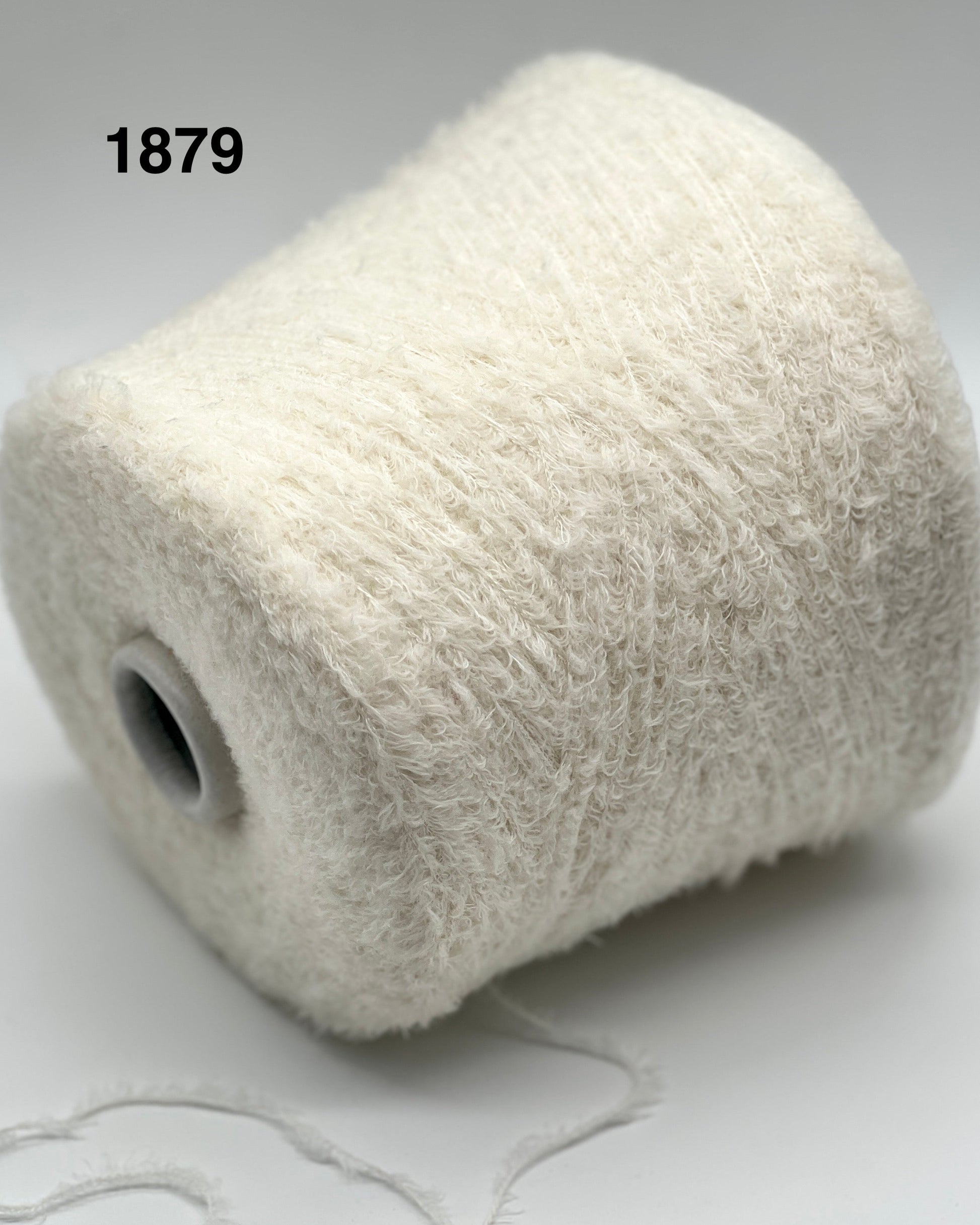 Spool of white yarn on a light gray background with '1879' text.