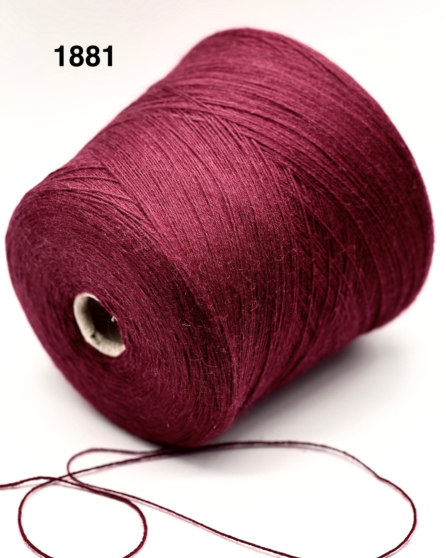 Spool of dark red yarn on a white background
