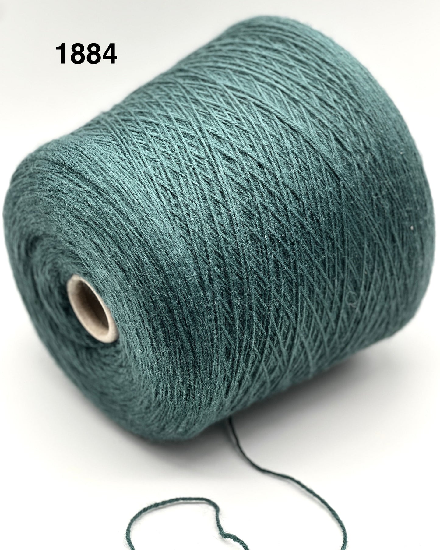 Roll of teal yarn on a white background with a visible brand number.