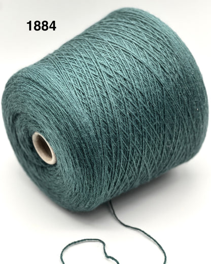 Roll of teal yarn on a white background with a visible brand number.