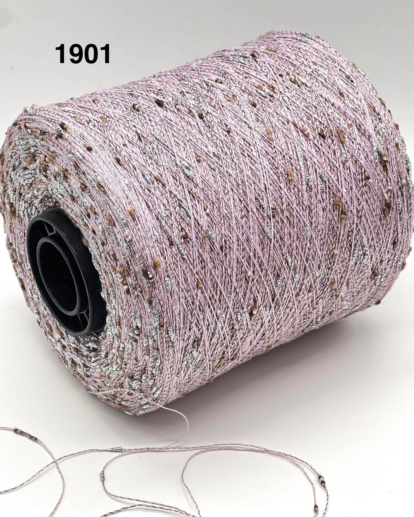 Spool of thread with a small amount on the ground, on a white background