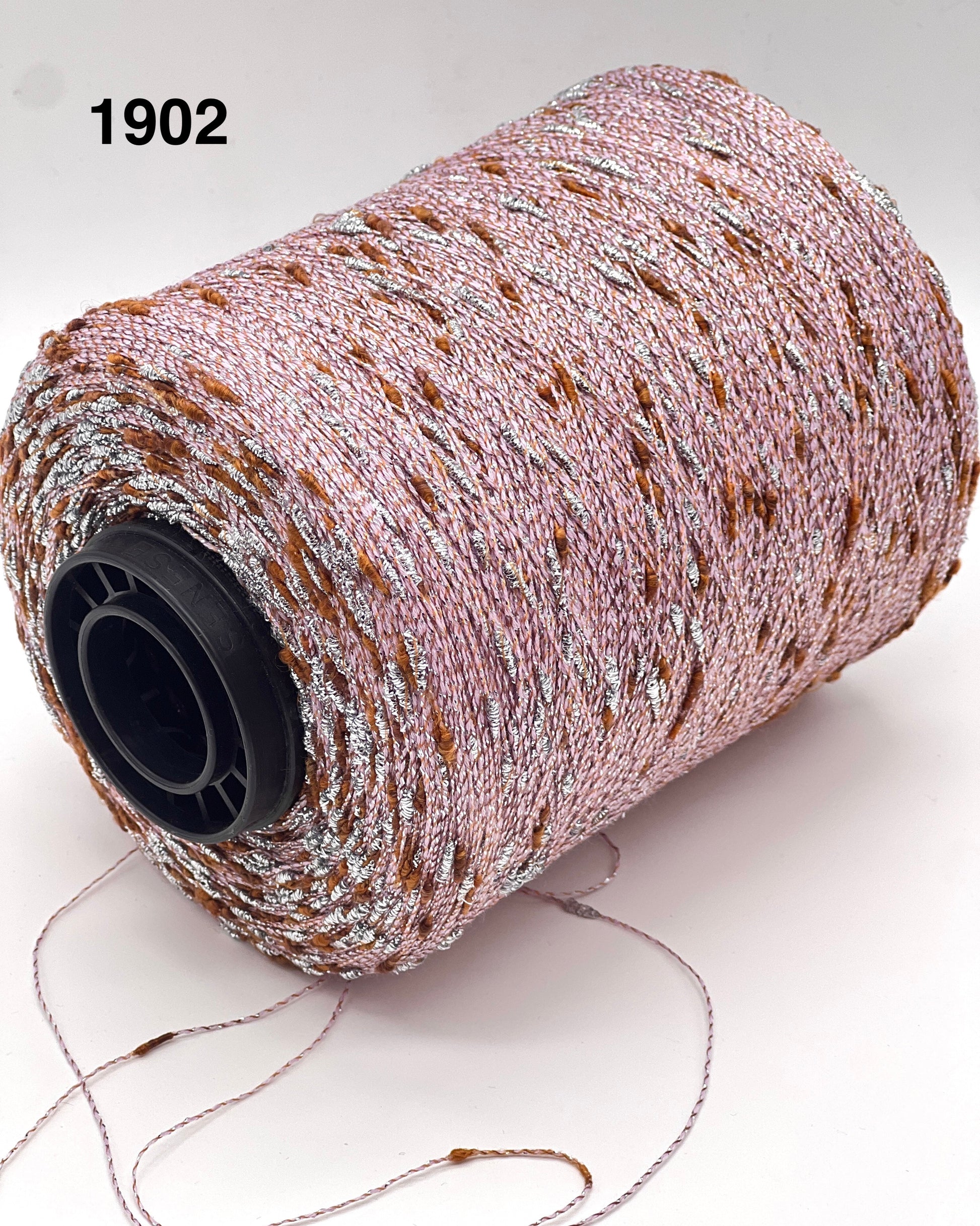 Spool of decorative ribbon with a metallic sheen on a light background