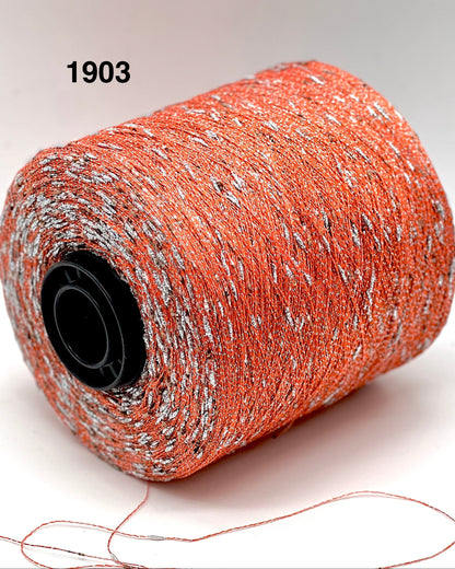 Spool of orange thread with speckles on a white background