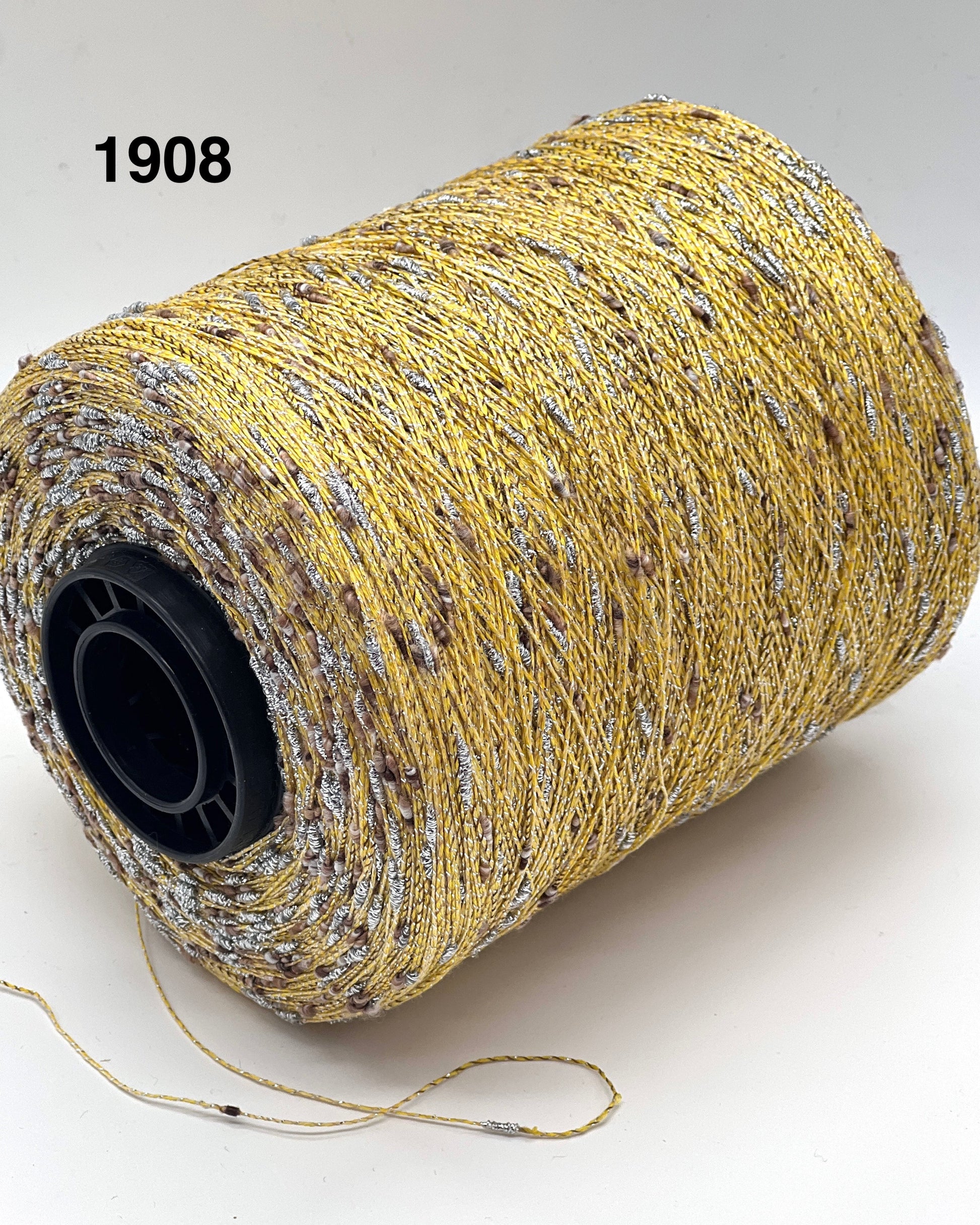Spool of yellow thread with a black core on a white background