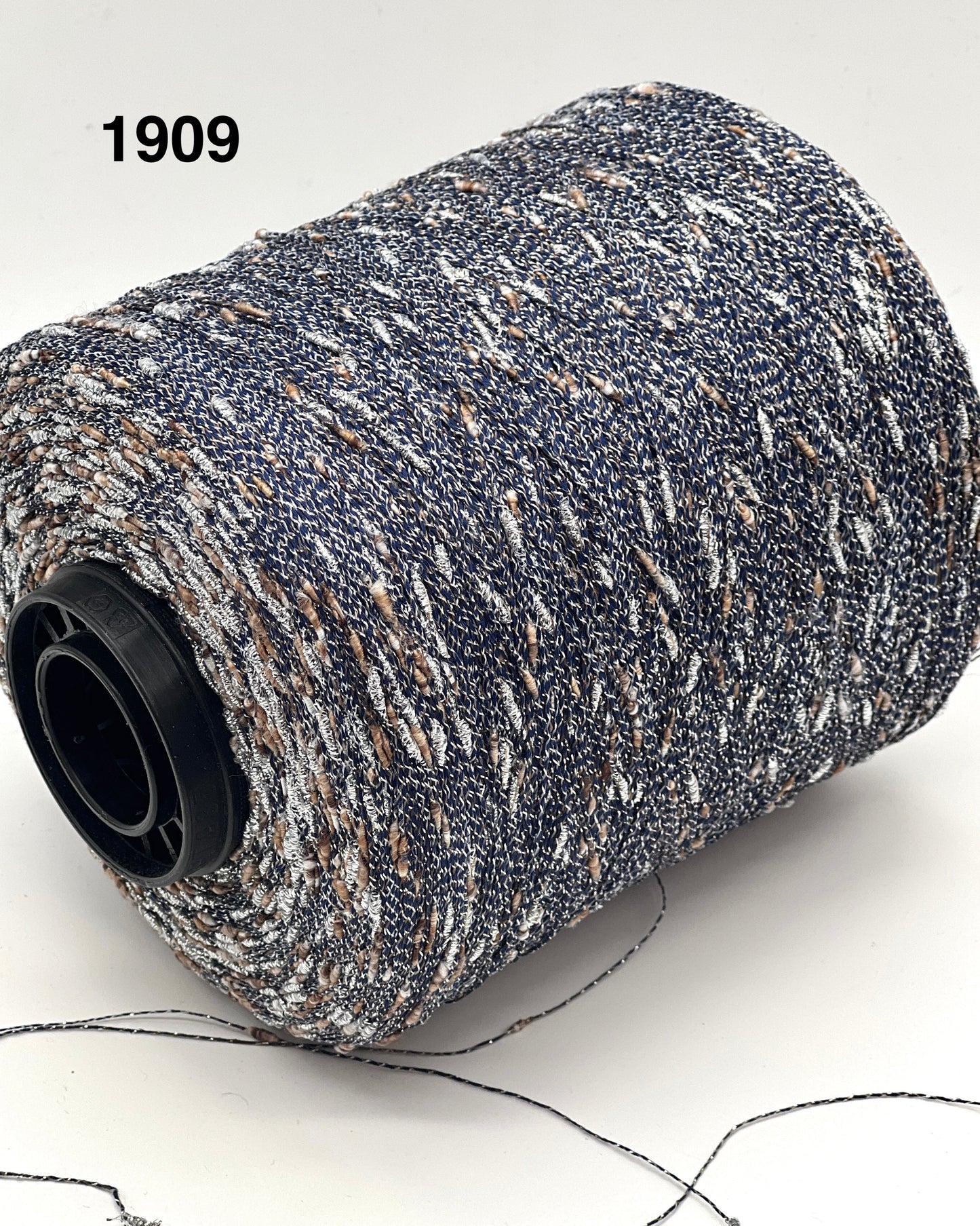 Spool of gray and white yarn with a black core on a white background, labeled '1909'.