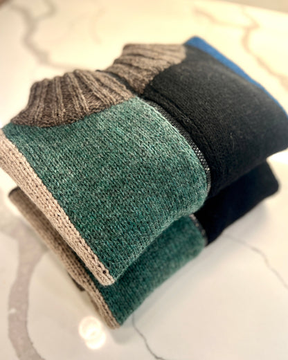 Stack of three pairs of socks in different colors on a marble surface