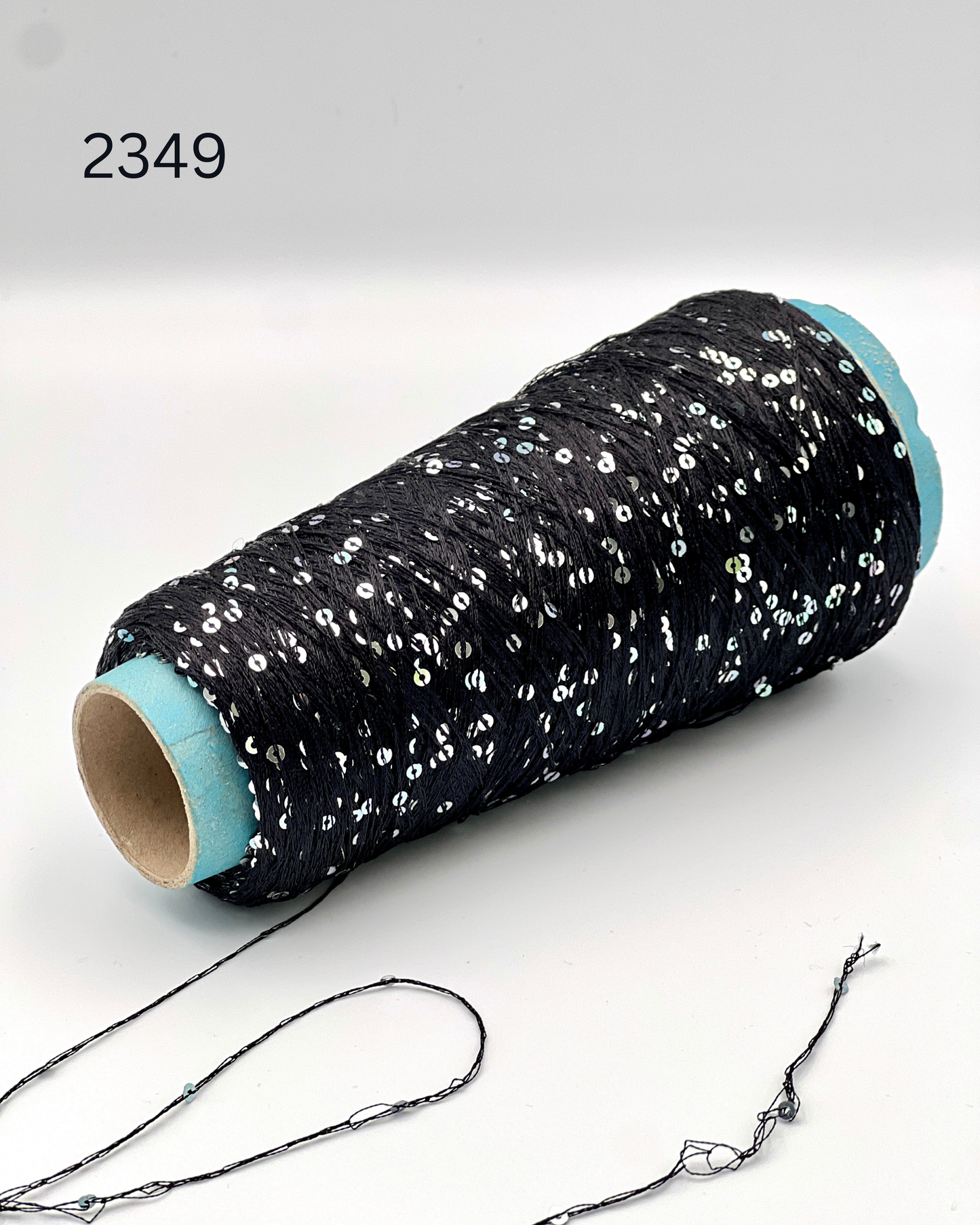 Luxury Italian paillettes yarn ESTRELLA by ECAFIL
Soft chainette sequin yarn on original cone
Italian fashion paillettes yarn for luxury knitwear
Designer companion yarn with integrated paillettes
Luxury Italian cone yarn with silver and green paillettes