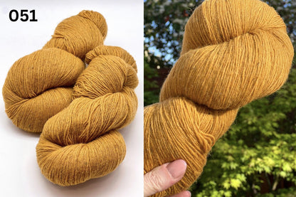 Small-batch dyed heritage skeins of 100% Latvian Dark-Headed Sheep Wool in earthy multicolor gradients like Green-Brown #052. The image shows the rustic single-ply texture and the sheep breed origin, representing the authentic wool traditions of Paces Vilnas Fabrika, Latvia. Available at iDOKNiT.com.