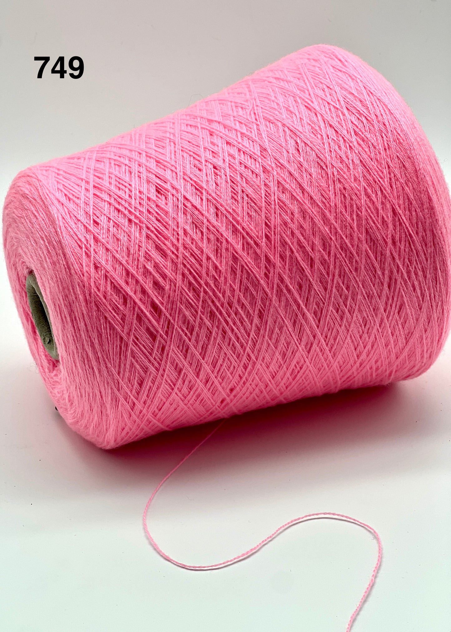 Pink spool of yarn on a white background