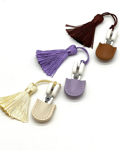 Professional iDOKNiT mini precision thread scissors for crafters. These 42mm spring-style snips feature a decorative tassel and protective cover, designed for sharp, precise trimming of yarn and embroidery floss. Compact and travel-ready accessory curated by iDOKNiT for knitting, crochet, and sewing project bags.