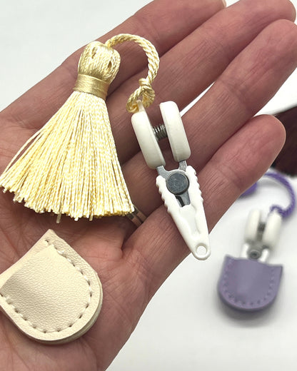 Professional iDOKNiT mini precision thread scissors for crafters. These 42mm spring-style snips feature a decorative tassel and protective cover, designed for sharp, precise trimming of yarn and embroidery floss. Compact and travel-ready accessory curated by iDOKNiT for knitting, crochet, and sewing project bags.