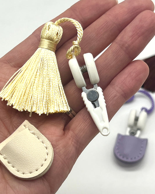 Professional iDOKNiT mini precision thread scissors for crafters. These 42mm spring-style snips feature a decorative tassel and protective cover, designed for sharp, precise trimming of yarn and embroidery floss. Compact and travel-ready accessory curated by iDOKNiT for knitting, crochet, and sewing project bags.