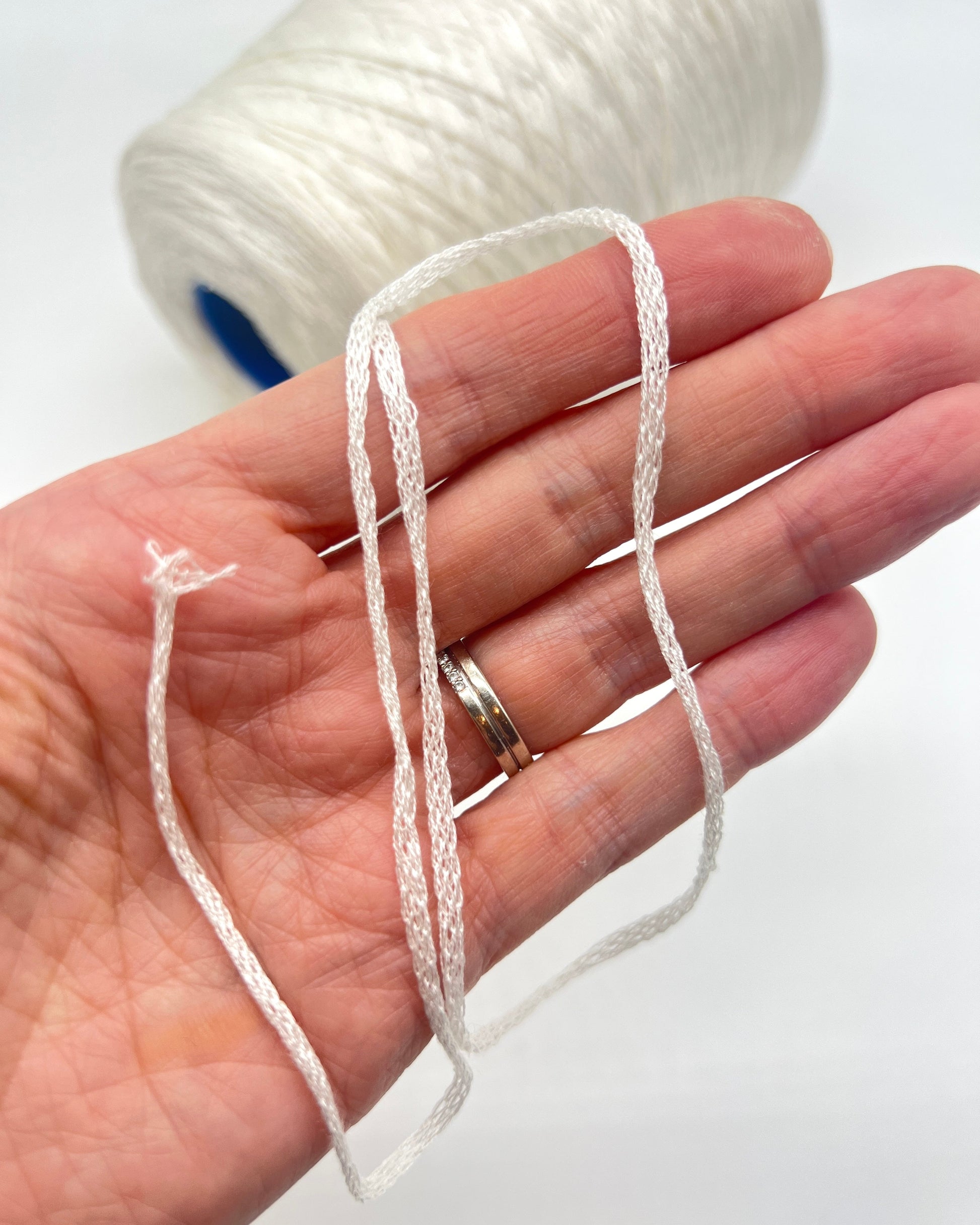 Luxury iDOKNiT fingering weight yarn, SETA SHAPPE by RiGo Italy. 100% Seta Shappe Silk featuring a sophisticated chainette structure for superior breathability and drape, 420m/100g. Authentic Italian-made silk on cones, color 2153 White, curated by iDOKNiT for elite hand and machine knitting projects.
