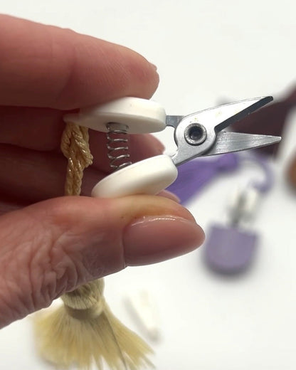 Professional iDOKNiT mini precision thread scissors for crafters. These 42mm spring-style snips feature a decorative tassel and protective cover, designed for sharp, precise trimming of yarn and embroidery floss. Compact and travel-ready accessory curated by iDOKNiT for knitting, crochet, and sewing project bags.