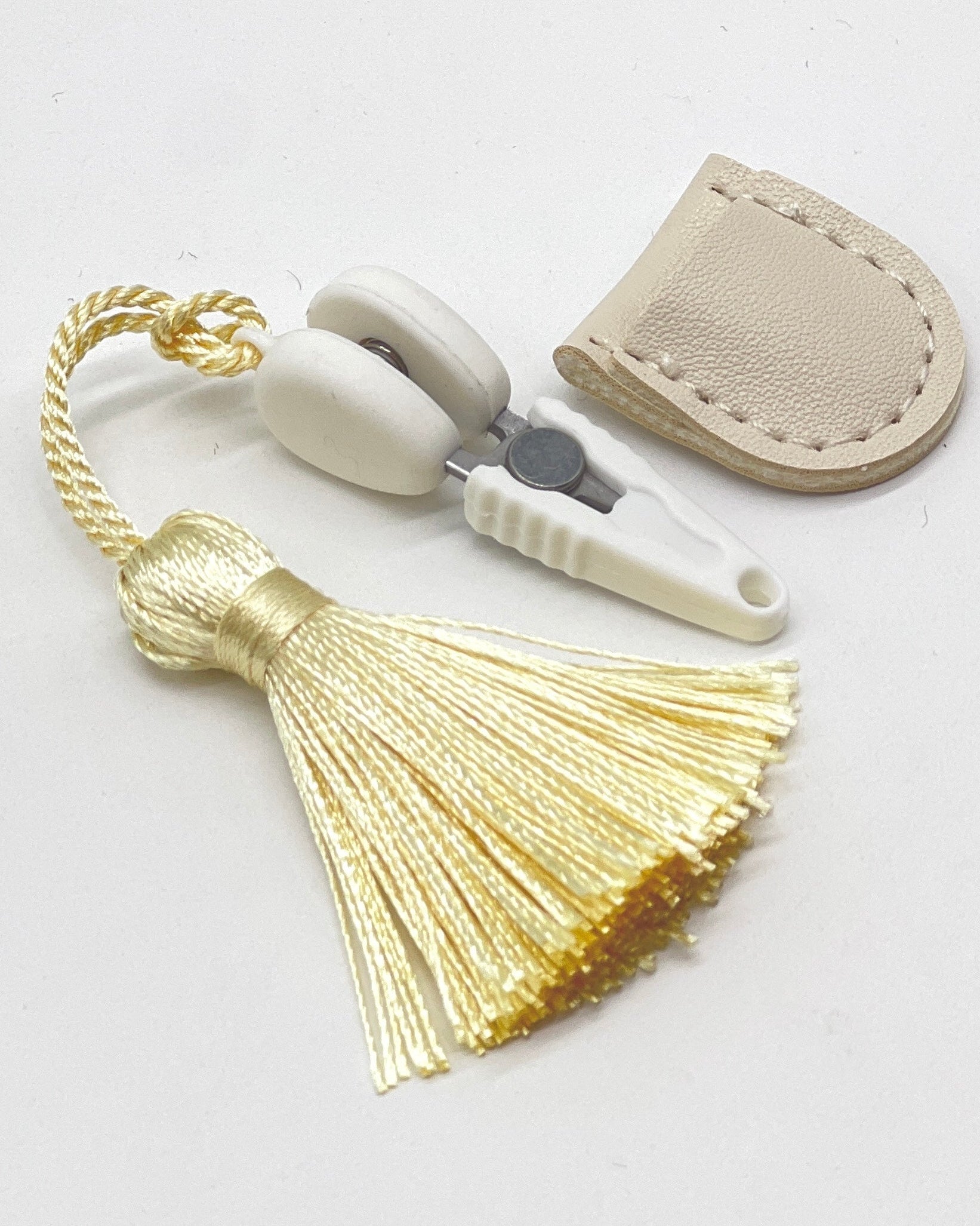 Professional iDOKNiT mini precision thread scissors for crafters. These 42mm spring-style snips feature a decorative tassel and protective cover, designed for sharp, precise trimming of yarn and embroidery floss. Compact and travel-ready accessory curated by iDOKNiT for knitting, crochet, and sewing project bags.