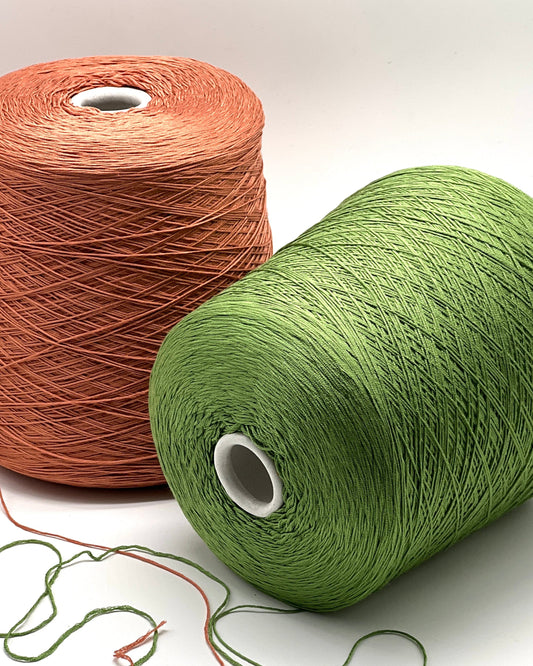 Two spools of yarn, one brown and one green, on a white background.