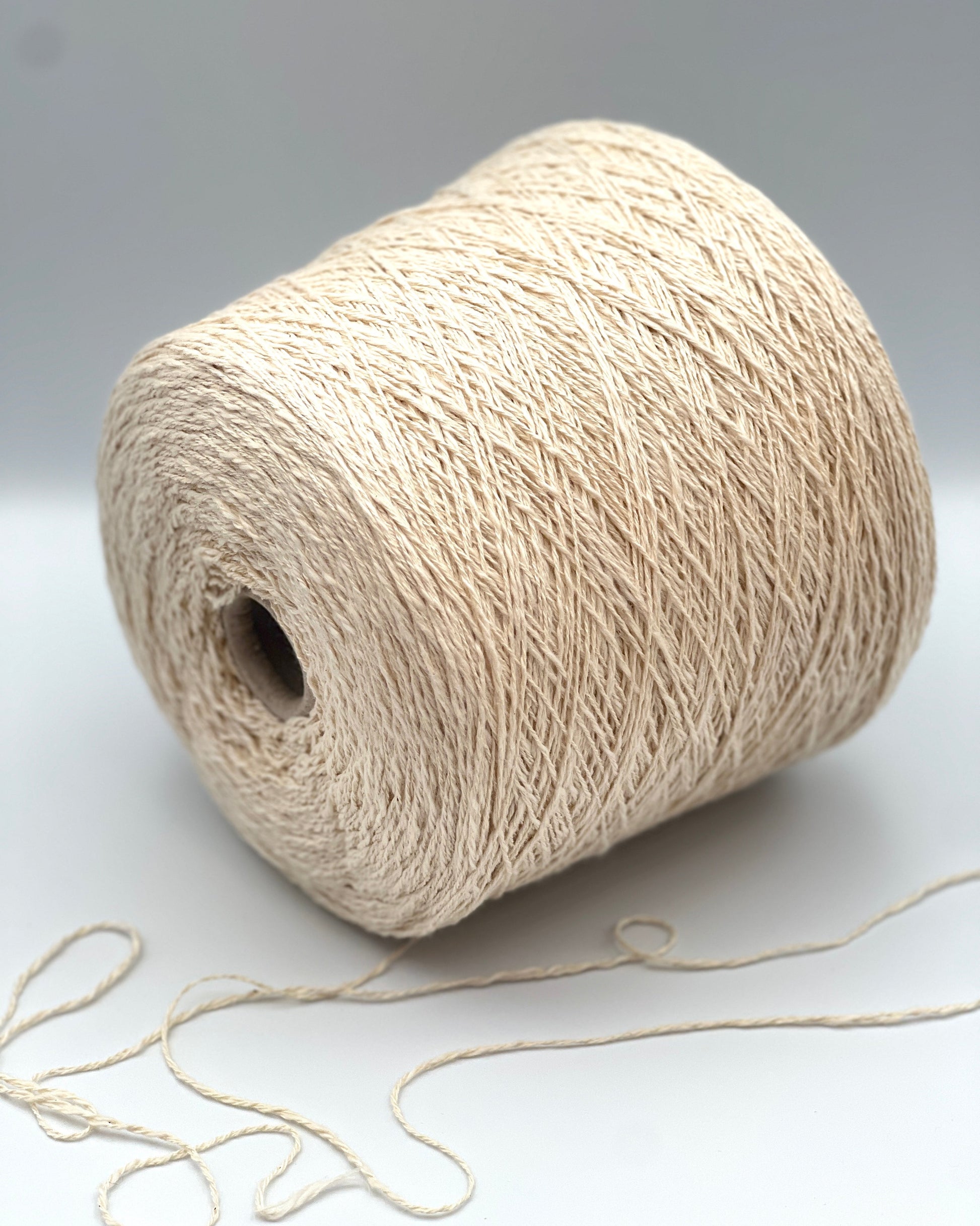 Cone of COTTON FLAME Italian flammé cotton yarn in natural cream color, premium sport weight cotton yarn for sweaters, cardigans, tops, and summer knitwear.