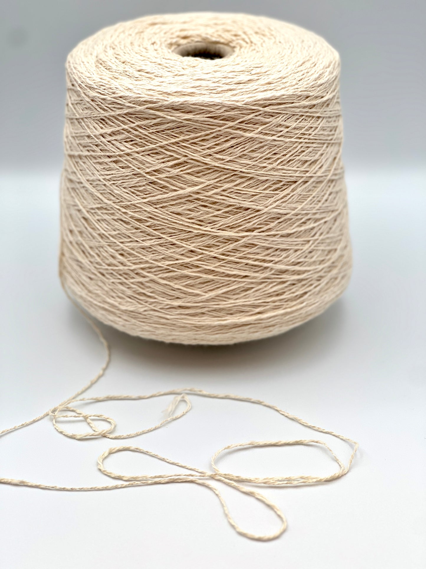 Cone of COTTON FLAME Italian flammé cotton yarn in natural cream color, premium sport weight cotton yarn for sweaters, cardigans, tops, and summer knitwear.