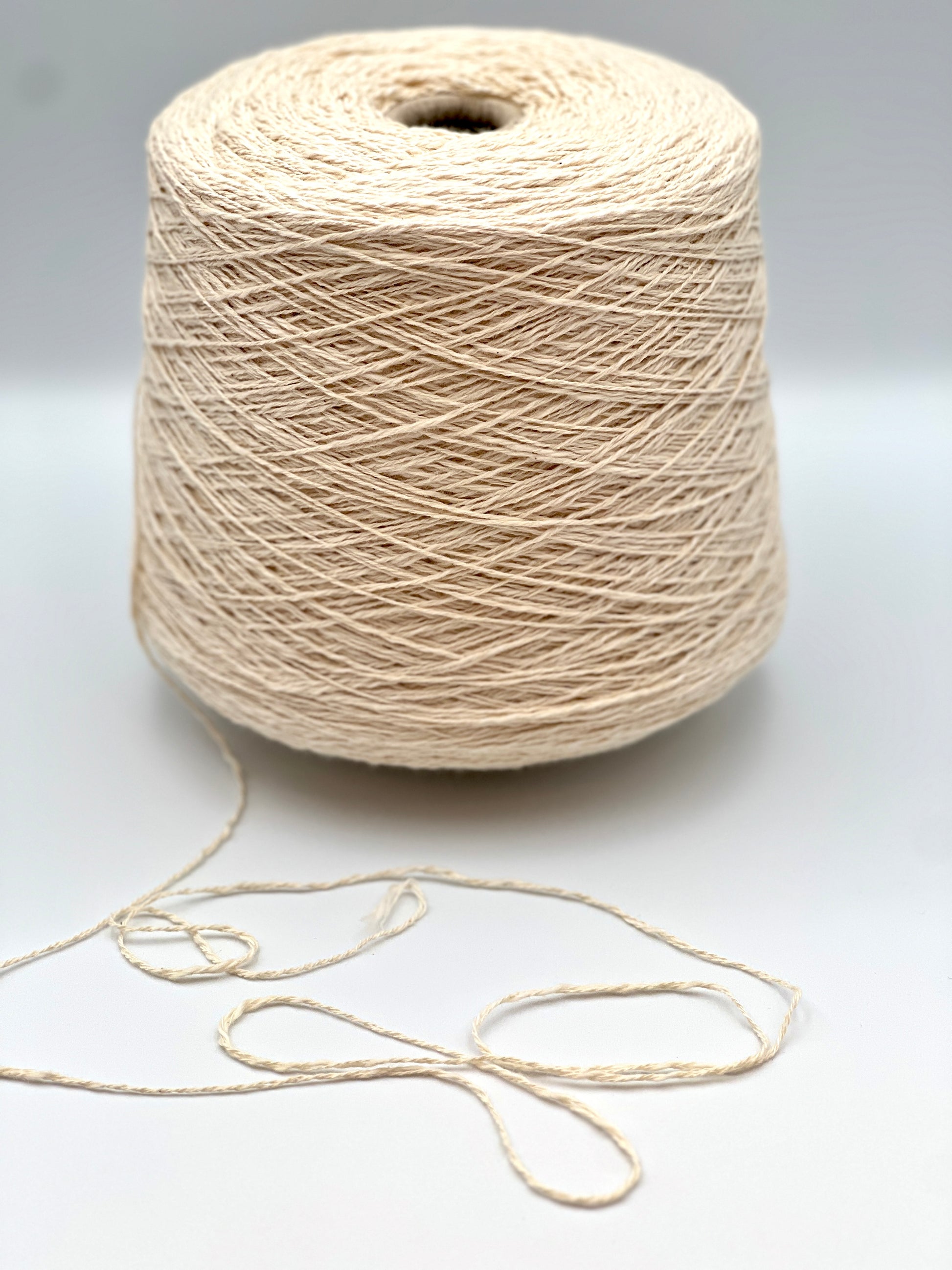 Cone of COTTON FLAME Italian flammé cotton yarn in natural cream color, premium sport weight cotton yarn for sweaters, cardigans, tops, and summer knitwear.