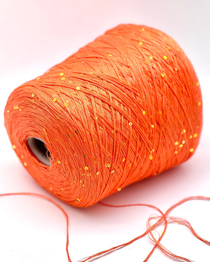 Orange spool of thread on a white background