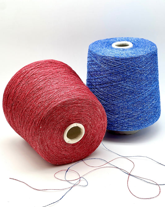 Two spools of red and blue yarn on a white background