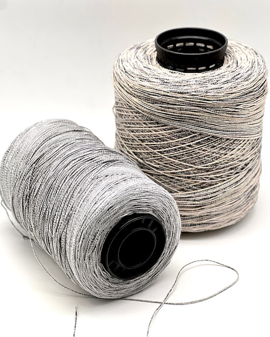 Two spools of gray thread on a white background