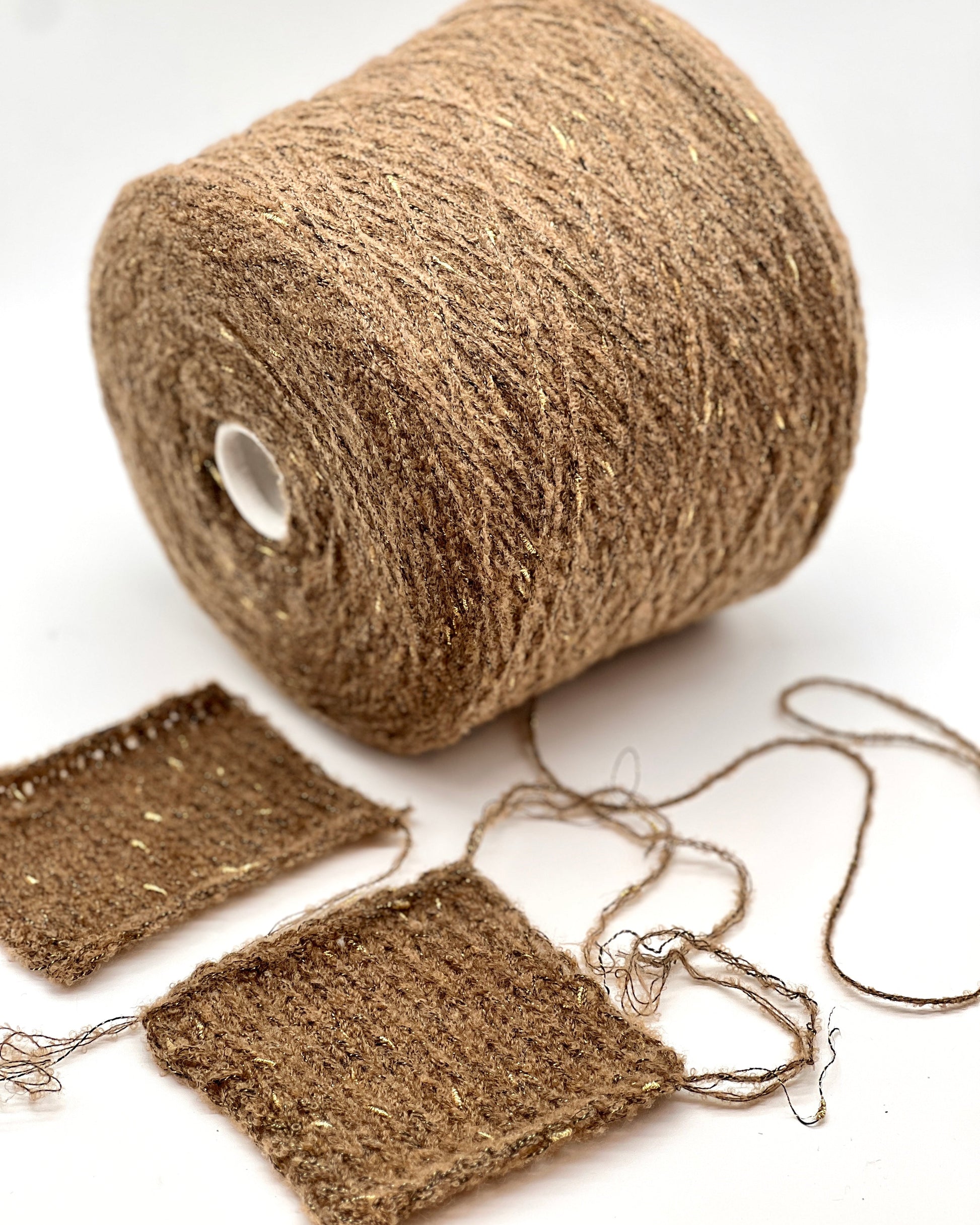 Roll of brown jute twine with a few strands spread out on a white background