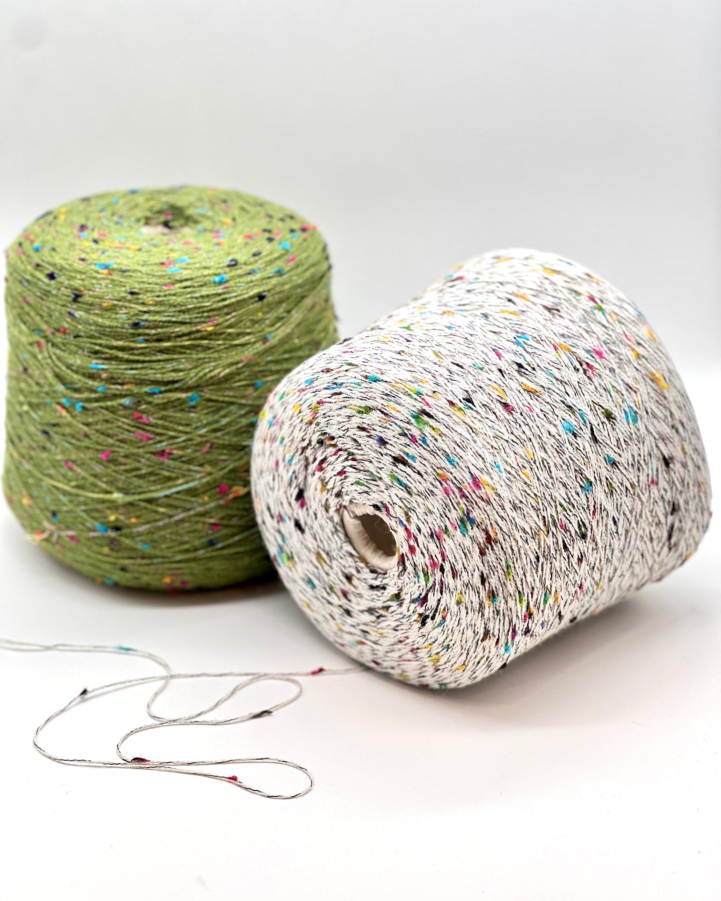 Two rolls of colorful yarn on a white background