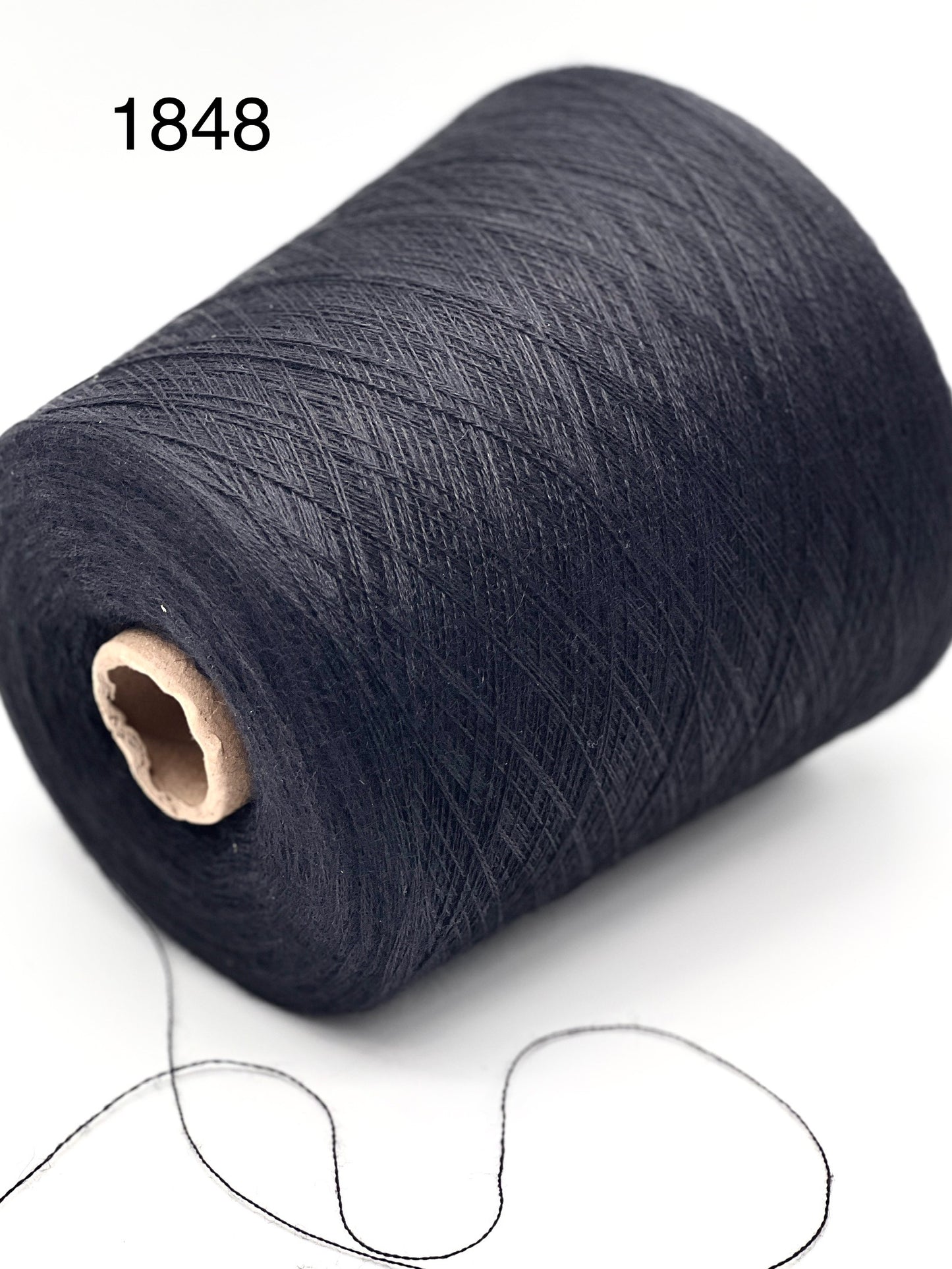 Spool of dark blue thread on a white background
