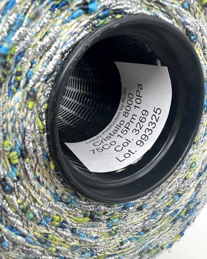 Close-up of a spool of thread with label inside, showing brand and product details.