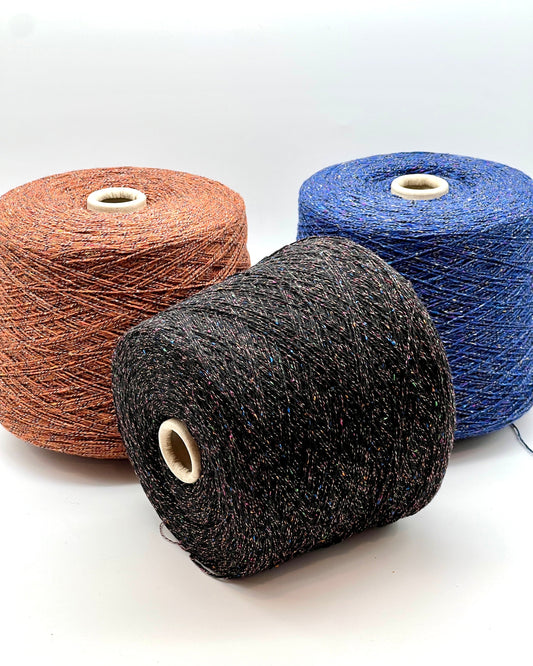Three spools of yarn in brown, black, and blue on a white background