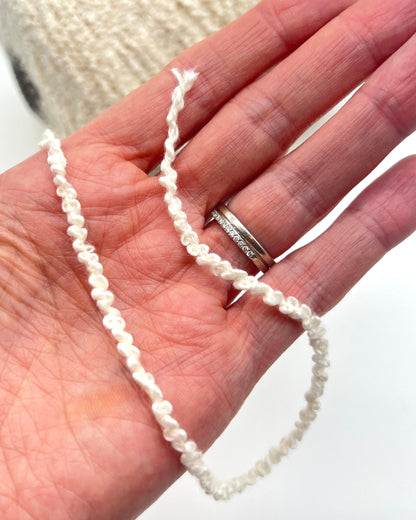 Italian cotton bouclé yarn on cone with looped textured surface